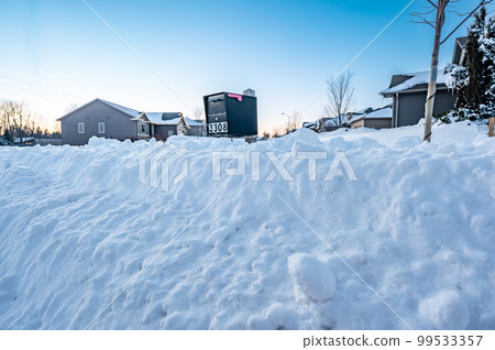 Selective focus on snowdrift blocking a residential mailbox. 99533357