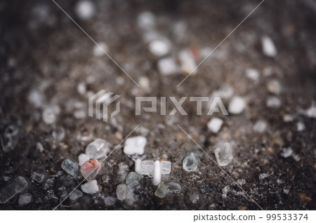 macro ground level closeup view of rock salt ice-melt on concrete with a frozen layer. macro ground level closeup view of rock salt ice-melt on concrete with a frozen layer. 99533374
