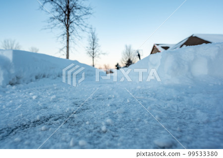 Selective focus ground level view of snow blown sidewalk section with path continuing.  99533380