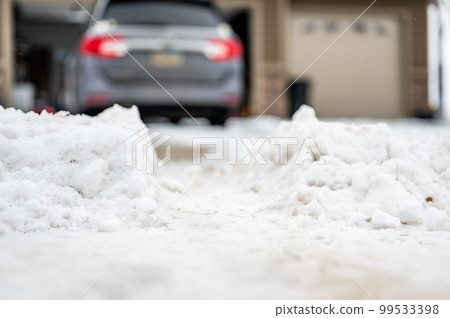 Snowbank at the end of a driveway left after city snowplows cleared a street. 99533398