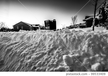 Residential mailbox blocked by a snow pile left by a plow after clearing a street. 99533409