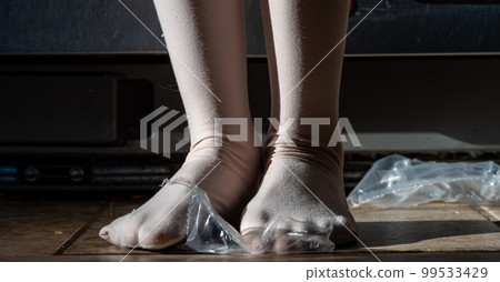 Focus on feet of a child standing on top of bubble wrap that has been popped.  99533429