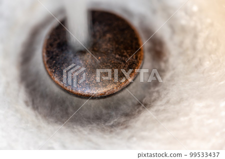 Water falling on an open sink drain. Water falling on an open sink drain. 99533437