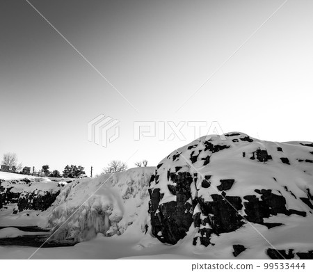 Sioux Falls Park during winter with frozen waterfall and snow cover. 99533444