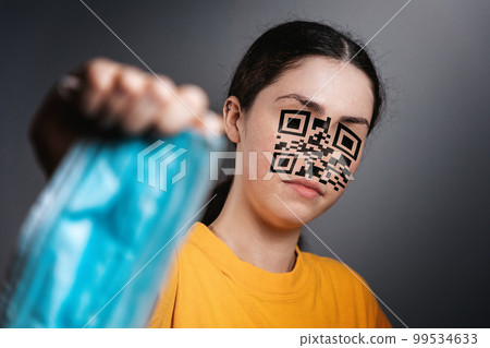 Portrait of a woman with a QR code instead of a face, shows a protective medical mask. Gray background. The concept of vaccination and online health passports 99534633