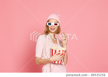 pretty blonde girl holding bucket of popcorn pretty blonde girl holding bucket of popcorn 99535256