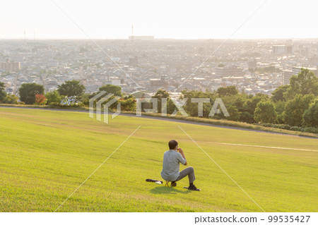 Person on grass, Daijouji park, Kanazawa, Japan. 99535427