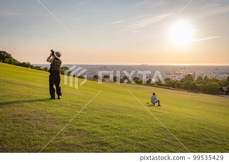 Two people on grass, Daijouji park, Kanazawa, Japan. 99535429