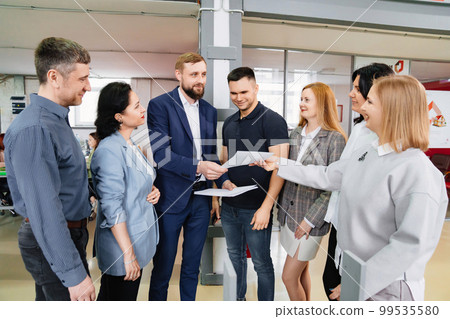 a group of men and women work with documents in coworking. concept of teamwork. a group of men and women work with documents in coworking. concept of teamwork. 99535580