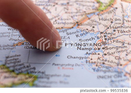 Finger pointing to Pyongyang, North Korea on colorful map with shallow depth of field, background blur. Concept geopolitical tensions. High quality photo Finger pointing to Pyongyang, North Korea on colorful map with shallow depth of field, background blur. Concept geopolitical tensions. High quality photo 99535836