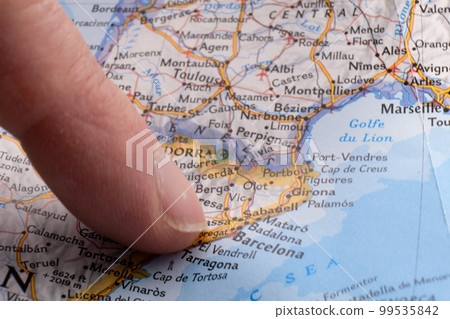 Finger pointing to Barcelona, Spain on a map with selective focus, background blur. High quality photo 99535842