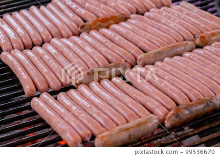 Process of grilling fresh meat sausages on big round grill Process of grilling fresh meat sausages on big round grill 99536670