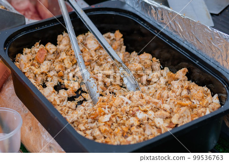 Cooked roasted chicken meat pieces in food container at local food market Cooked roasted chicken meat pieces in food container at local food market 99536763