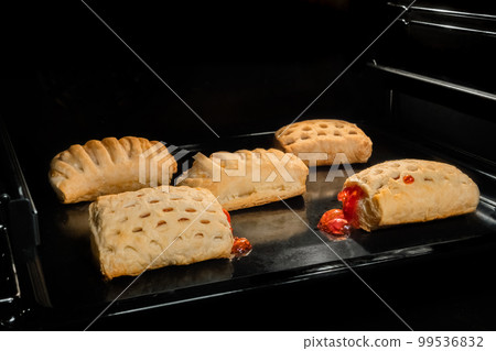 Five baked homemade buns with fruit jam in electric oven 99536832