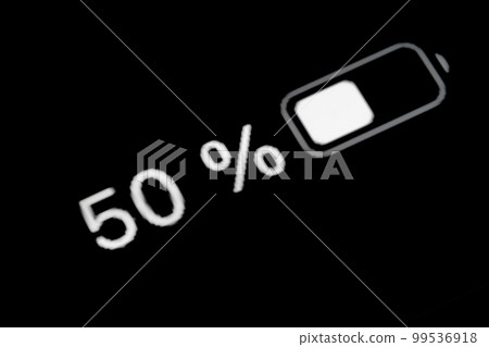 Smartphone charged battery level indicator - fifty, 50 percent: close up macro 99536918