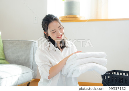A woman folding laundry 99537182
