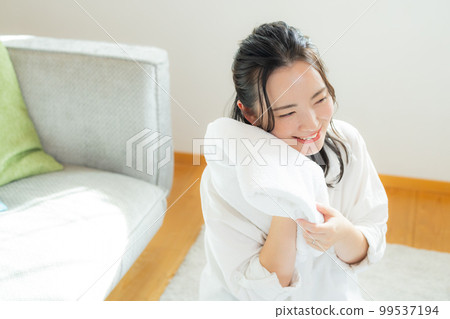 A woman folding laundry 99537194