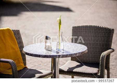 Empty tables outside between lunch hours along a cobblestone alley in a European city, a veranda, a cafe Empty tables outside between lunch hours along a cobblestone alley in a European city, a veranda, a cafe 99537267