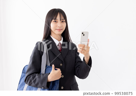 A high school girl using a smartphone while commuting to school 99538075