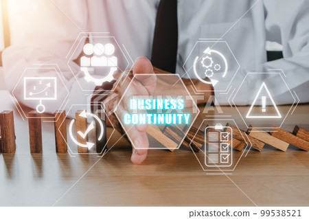 Business continuity concept, Business person hand stopping falling wooden dominoes effect from continuous toppled with business continuity icon on virtual screen. Business continuity concept, Business person hand stopping falling wooden dominoes effect from continuous toppled with business continuity icon on virtual screen. 99538521