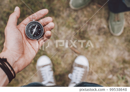 Traveler holding compass in hand Traveler holding compass in hand 99538648