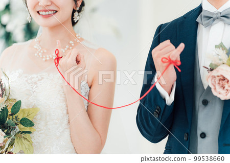 A bride and groom tied with a red thread at a wedding hall (bridal wedding) 99538660
