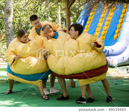 Men and women in large sumo suits having fun in adventure park 99539493