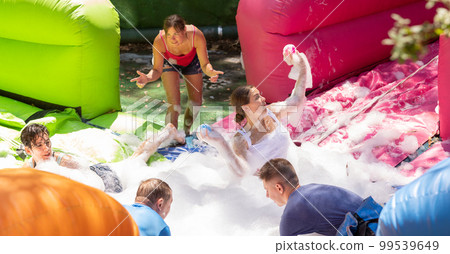 Positive men and women playing interesting game in bubble pool 99539649