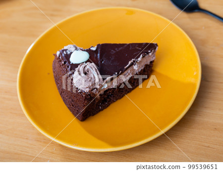 There is piece of brown chocolate cake with chocolate sauce 99539651