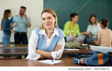 Portrait of a student girl with a pen and a copybook, preparing for classes 99539672