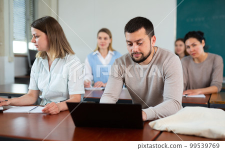 Two students studies on a laptop and writes a synopsis Two students studies on a laptop and writes a synopsis 99539769