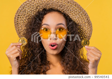 Woman with bitcoin, crypto currency. Golden coins, yellow background.  99540541