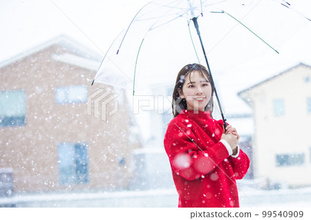 A woman holding an umbrella in the snow snow A woman holding an umbrella in the snow snow 99540909