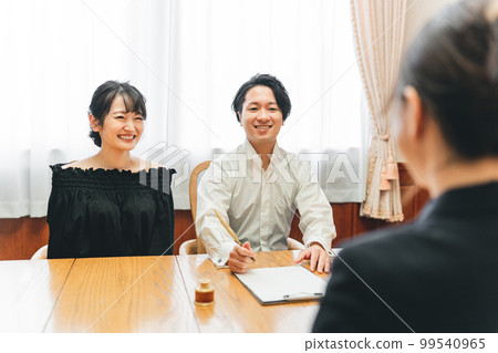 Men and women meeting with concierge hotelier wedding planner and signing contract (marriage agency) 99540965