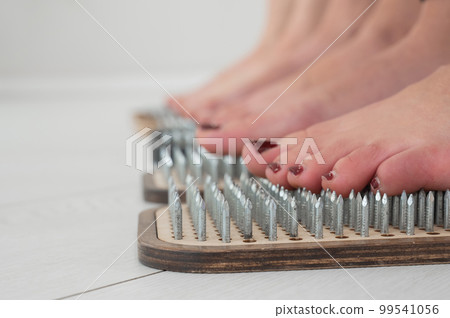 Close-up of three women's feet on sadhu's nails.  99541056