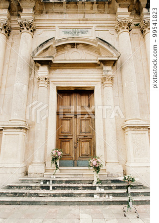 Pedestals with flowers stand on the steps of the church 99541823