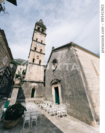 Rows of decorated chairs stand in the courtyard in front of an old church Rows of decorated chairs stand in the courtyard in front of an old church 99541903