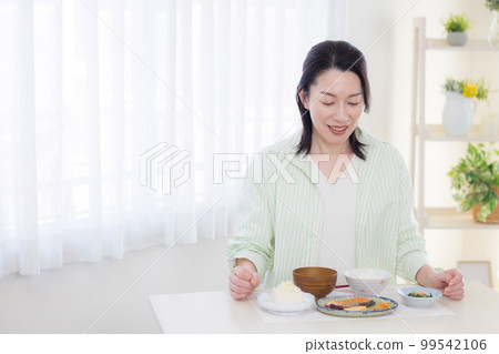 用餐場景 一位中年婦女正在用餐 用餐場景 一位中年婦女正在用餐 99542106