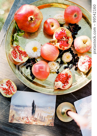 Fruit platter on wooden table next to landscape photography 99542160