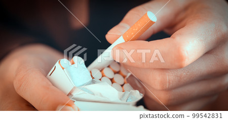 Male hands hold a pack of cigarettes, closeup view. Male hands hold a pack of cigarettes, closeup view. 99542831