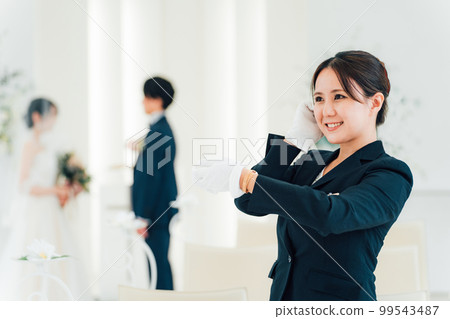 Wedding planner, bridesmaid, attendant, hotelier woman looking at watch at wedding hall/hotel Wedding planner, bridesmaid, attendant, hotelier woman looking at watch at wedding hall/hotel 99543487