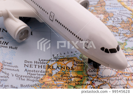 Close up of a miniature passenger plane on a colorful map showing Amsterdam, Netherlands through selective focus, background blur. High quality photo 99545628