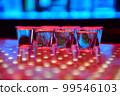 Vodka or tequila shots on bar counter in night club 99546103