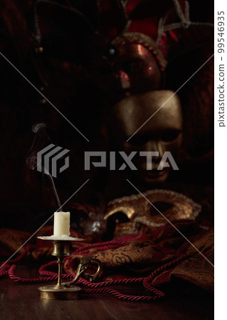 Still life with an extinguished candle and carnival masks. 99546935