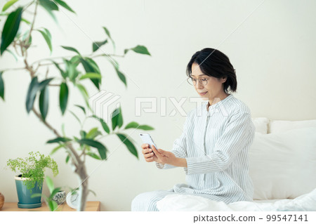 Middle woman wearing glasses looking at smartphone 99547141