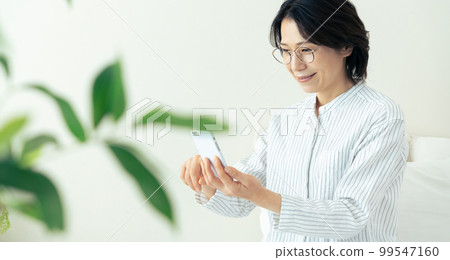 Middle woman wearing glasses looking at smartphone 99547160