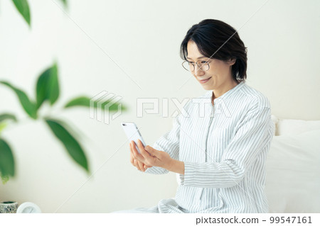 Middle woman wearing glasses looking at smartphone 99547161