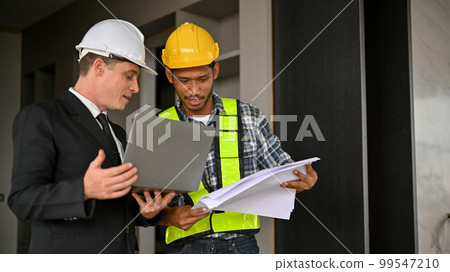 Asian male construction engineer working with a Caucasian businessman while inspecting the building. Asian male construction engineer working with a Caucasian businessman while inspecting the building. 99547210