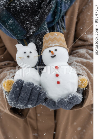 person with two snowmen 99547517