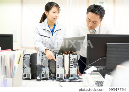 身穿工作服的員工向處於職業生涯中期的員工解釋 PC 連接 企業形象 99547764